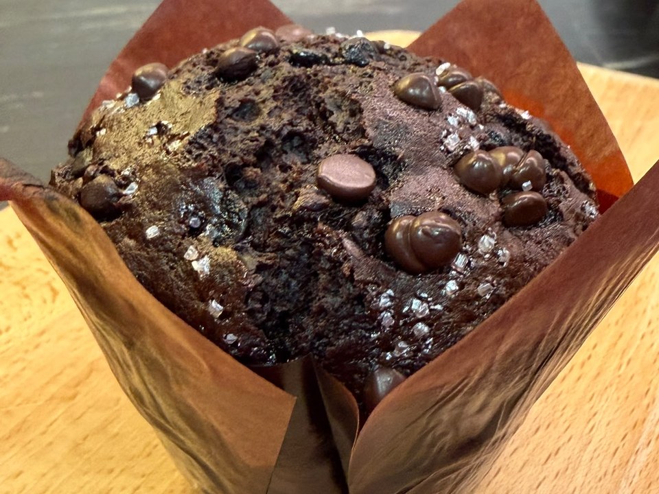 Onyx Muffin — a deep dark double chocolate muffin topped with chocolate chunks, in a brown tulip wrapper